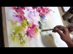 a person is painting flowers on an easel