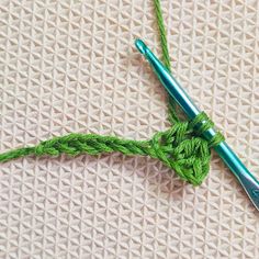 the crochet hook is being used to make a knot