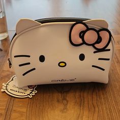 a hello kitty purse sitting on top of a wooden table