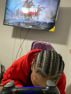 a woman sitting in front of a tv with a video game on the wall behind her