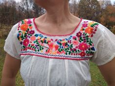 "Vintage 80s tailored cotton short sleeve blouse. Mexican hand embroidery blouse. Beautiful multi colour floral traditional design. Cotton blouse. From shoulder to shoulder 16\"41cm Bust 40\"102cm Sleeve length 4,5\"11cm Length 25,5\"65cm." Spring Fitted Blouse With Embroidered Border, Fitted Blouse With Embroidered Border For Spring, Spring Short Sleeve Blouse With Embroidered Border, Multicolor Embroidered Floral Print Short Sleeve Blouse, Multicolor Embroidered Floral Print Top With Short Sleeves, Multicolor Floral Print Embroidered Top With Short Sleeves, Folk Style Embroidered Floral Print Short Sleeve Top, Traditional Multicolor Embroidered Floral Top, Summer Short Sleeve Embroidered Top