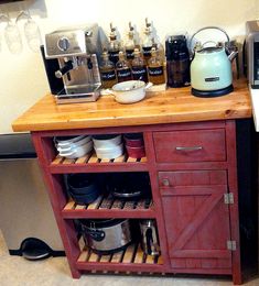 a small kitchen island with lots of pots and pans on it next to a microwave