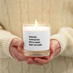 a person holding a candle that says midwife supporter baby catcher in black text