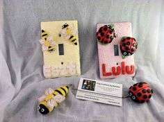 three ladybugs are sitting next to a light switch plate and business card holder