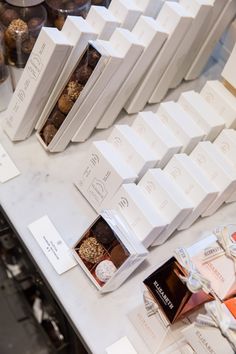 many different types of chocolates are on display at a store counter with price tags