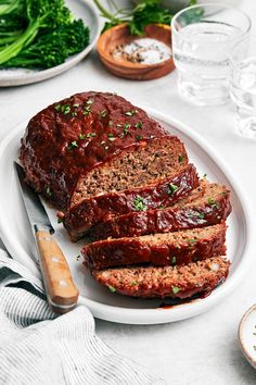 sliced meatloaf on a plate next to broccoli