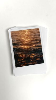 an open photo book with the sun reflecting in water