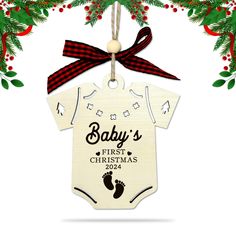 a baby's first christmas ornament hanging from a tree