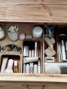 an open drawer with various items in it and on the bottom shelf is a hairbrush, combs, scissors, etc