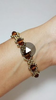 a woman's arm with a gold bracelet and brown beaded beads on it