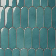 a close up view of a blue tile wall with curved metal grates on it