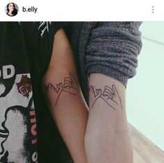 two people with tattoos on their arms holding each other's hands and one has the word love written in cursive writing