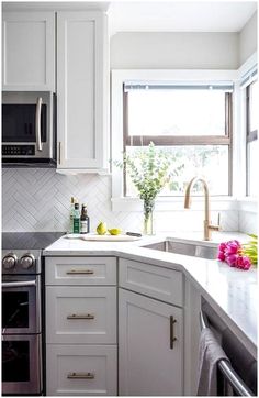 a kitchen with white cabinets and stainless steel appliances