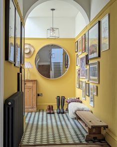 a hallway with yellow walls and pictures on the wall