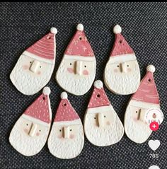 six ceramic christmas ornaments with santa hats and noses on them, all in white and pink