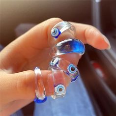 a person is holding three glass rings in their hand