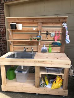 an outdoor kitchen made out of pallets and wooden planks, with a sink in the center