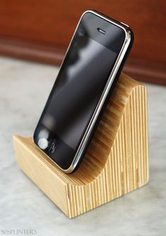 an iphone is sitting on top of a wooden stand