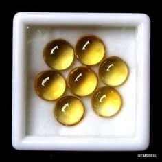 some yellow balls are in a white square bowl