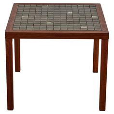 a wooden table with tile top and legs on white background, isolated for use in interior or exterior design