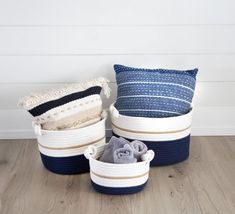 three blue and white baskets sitting on top of a wooden floor