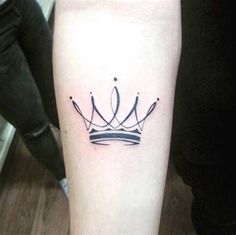 a black and white crown tattoo on the arm