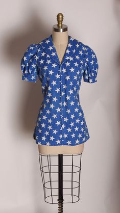 1970's Blue and White America Short Sleeve Novelty Stars Print Sailor Style Blouse  This blouse features: *Blue and white colors *Stars print *Sailor style back *Front zipper up front  Size: Small  Measurements: Bust: 35" Waist: 32" Length: 27" Condition: Great. Has underarm fading on both sides. Sold as is.  If you have any questions, please ask. Find even more Vintage Smalls at: https://www.etsy.com/shop/NaughtyKittyVintage?section_id=17610195&ref=shopsection_leftnav_7 Thanks! -NaughtyKittyVin Retro Blue Collared Top, Retro Fitted Blue Blouse, Fitted Blue Top With Star Print, Blue Retro Fitted Blouse, Blue Vintage Blouse With Collar, Striped Sailor Long Sleeve Top, Sailor Style, Sailor Fashion, Style Blouse