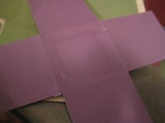 the paper is cut into squares and placed on top of another piece of purple material