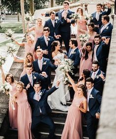 a large group of people posing for a photo on some steps with their arms in the air