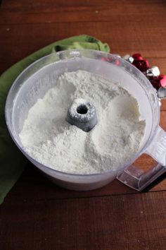 a food processor filled with flour on top of a wooden table