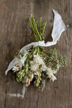 a bunch of flowers that are sitting on a table together and tied to a piece of paper