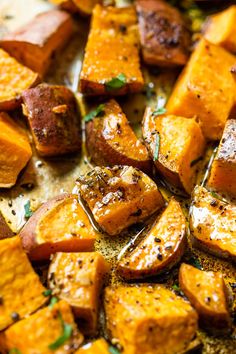 roasted sweet potatoes with herbs and seasoning on a baking sheet