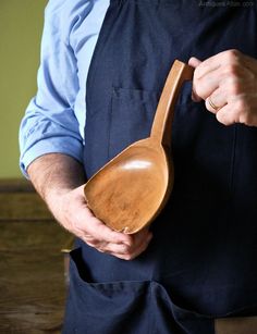 a person wearing an apron holding a wooden spoon