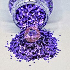 a jar filled with purple glitter sitting on top of a table