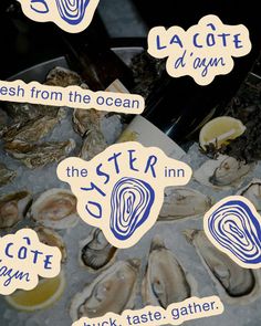 an assortment of oysters on ice with stickers attached to the top and bottom