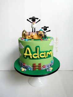 there is a cake that has been decorated with animals on it and the name adam