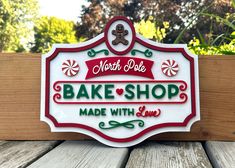 a sign that says bake shop made with love on the side of a wooden fence