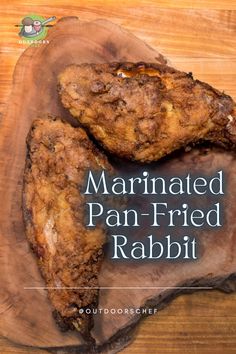 two pieces of fried chicken on top of a wooden cutting board with the words marinated pan - fried rabbit