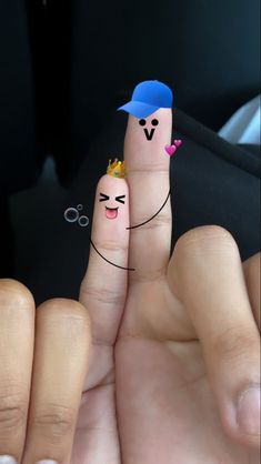 two fingers with faces drawn on them, one is holding the other's finger