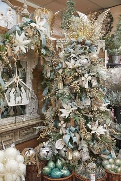 a decorated christmas tree in a store with ornaments and other decorations on display behind it