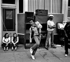 black and white photograph of people sitting on the sidewalk