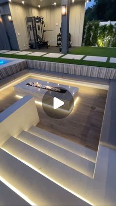 the inside of a house with stairs lit up at night and an outdoor fire pit in the center