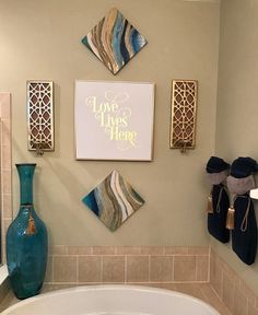 a bathroom decorated with blue vases and pictures on the wall above the bathtub