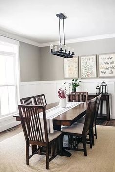 a dinning room table with chairs and pictures on the wall