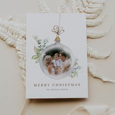 an ornament hanging from a christmas tree with two people in it and the words merry christmas