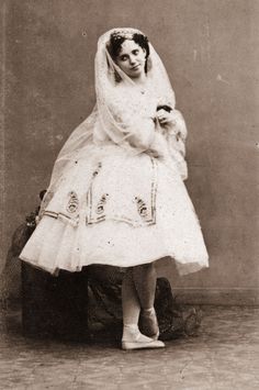 an old photo of a woman in a wedding dress with a dog on her lap