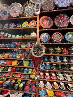 many colorful plates and bowls are on display