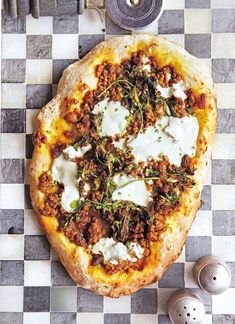 a pizza sitting on top of a checkered table