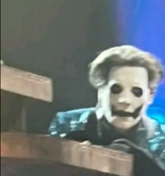 a man wearing a creepy mask on stage