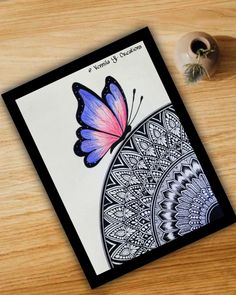 a card with a butterfly on it sitting next to a flower pot and a plant